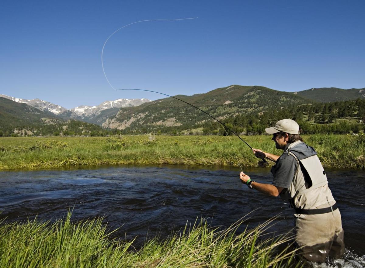 A guy fly fishing in a river
