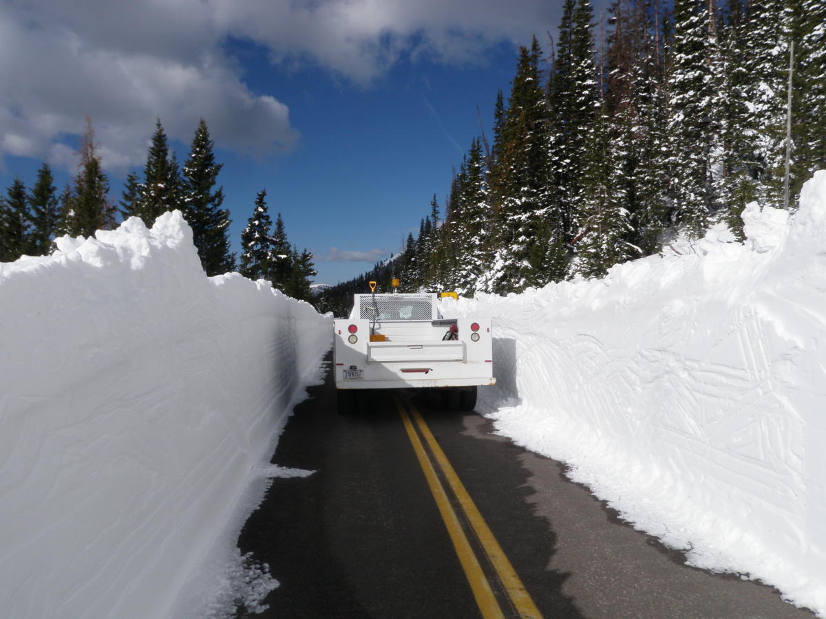 Truck dwarfed by snowbanks on trail ridge road