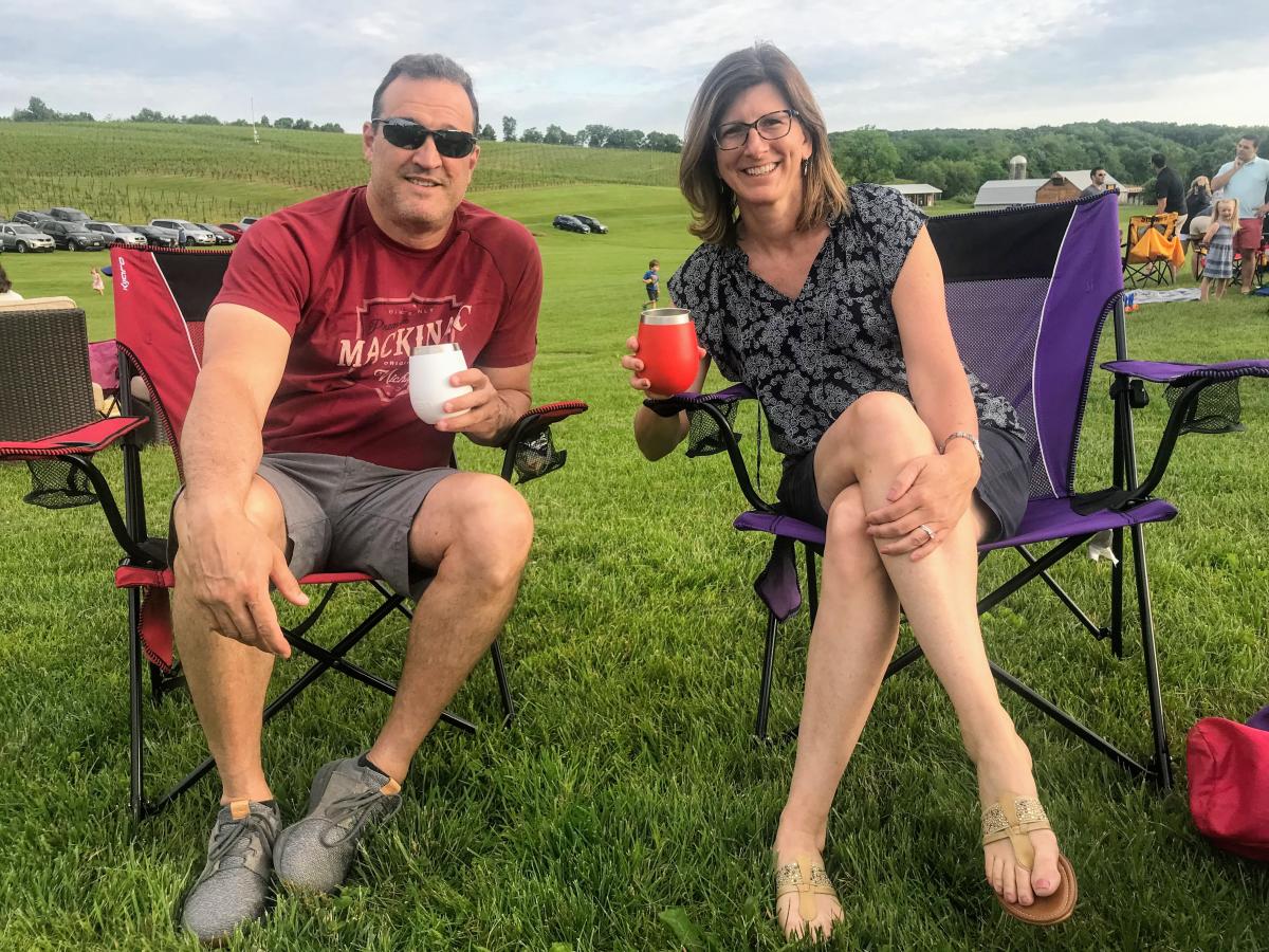 A man and woman sitting and drinking wine outdoors 