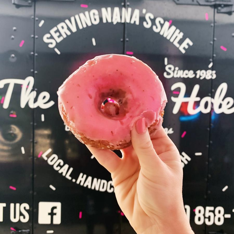 customer shows off their favorite flavor from Donut Hole food truck.