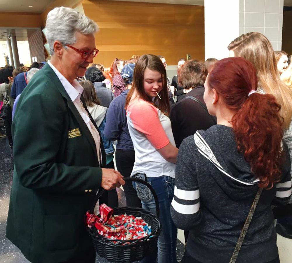 A Grand Wayne Convention Center host offers candy to event attendees