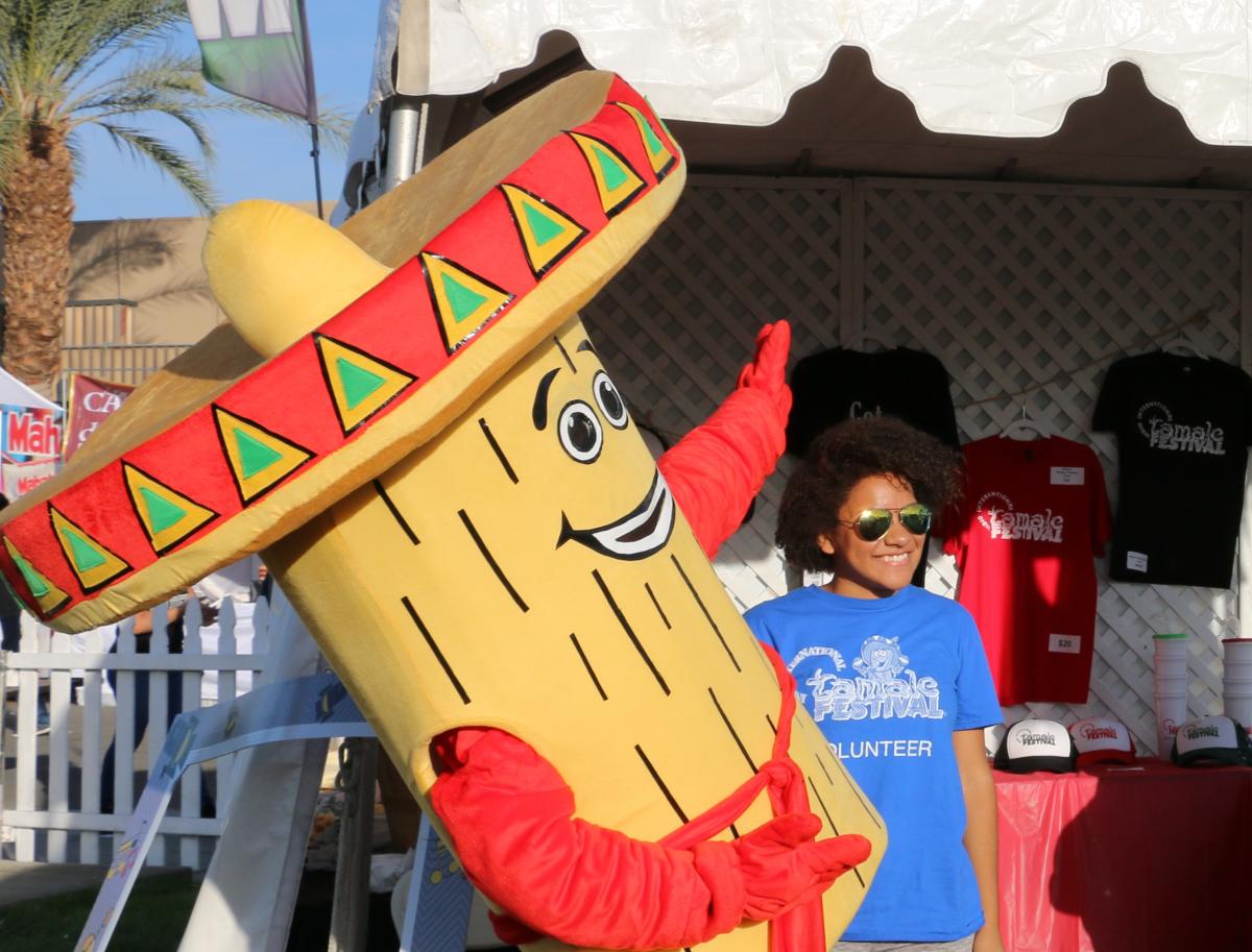 A volunteer at the Indio International Tamale Festival with the Festival Mascot