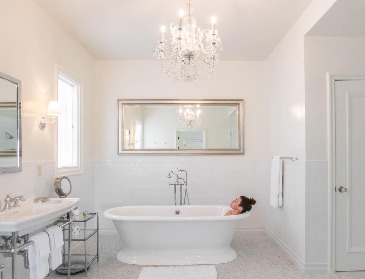 Woman relaxing in bathtub at The Willows Historic Palm Springs Inn