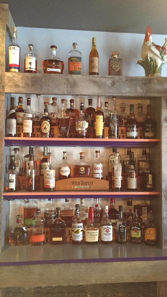 Four shelves of bourbon at the purple poulet restaurant