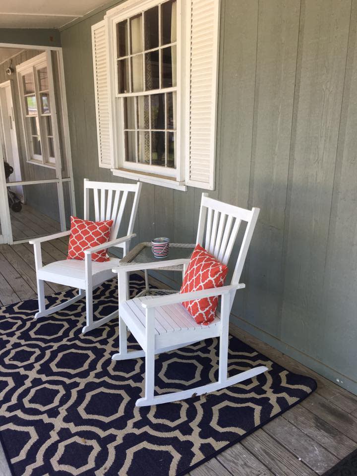 Two wooden rocking chairs on a front porch.