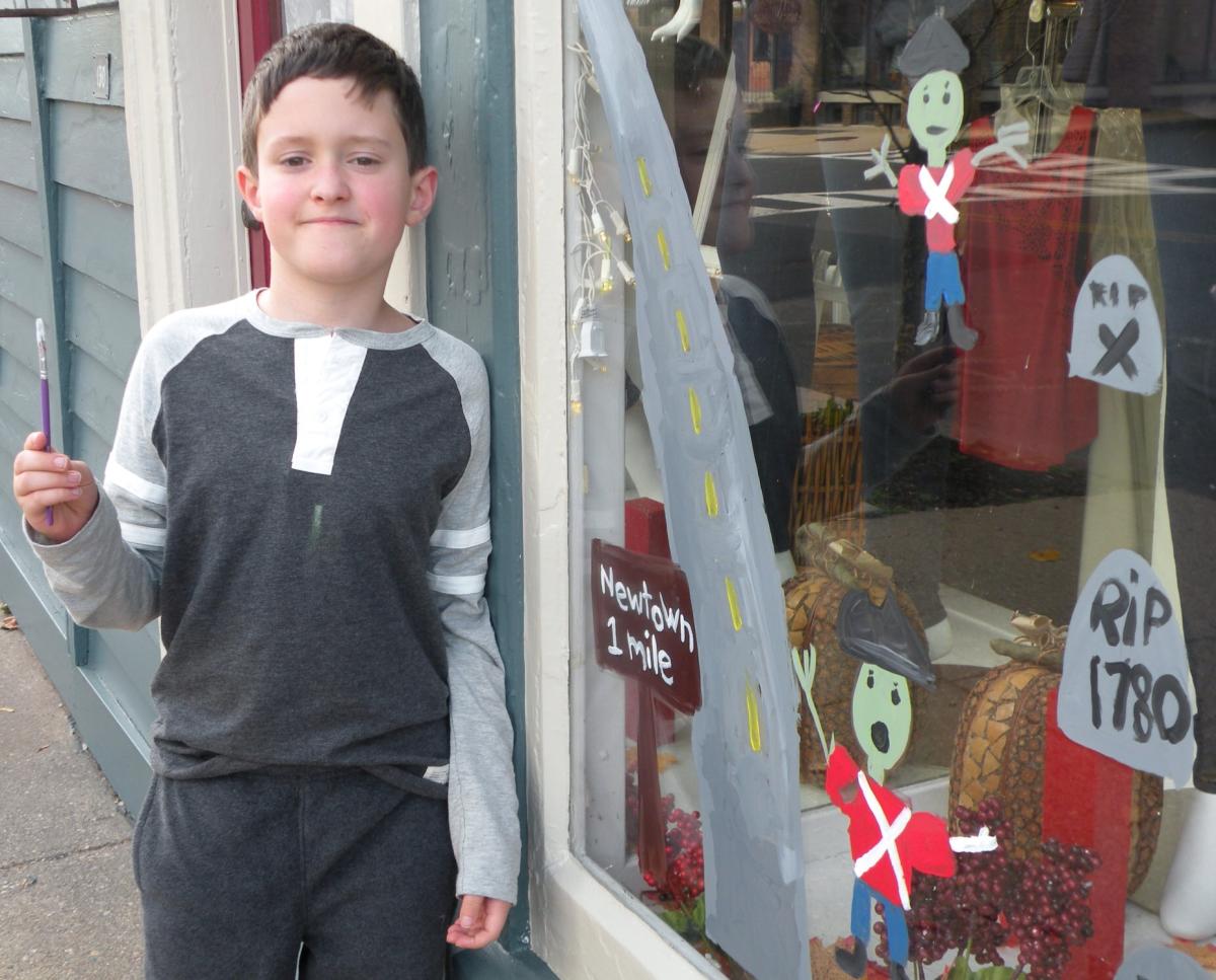 Little boy painting Newtown window