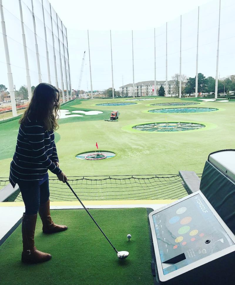 A woman prepared to tee off at a TopGolf driving range in Virginia Beach.