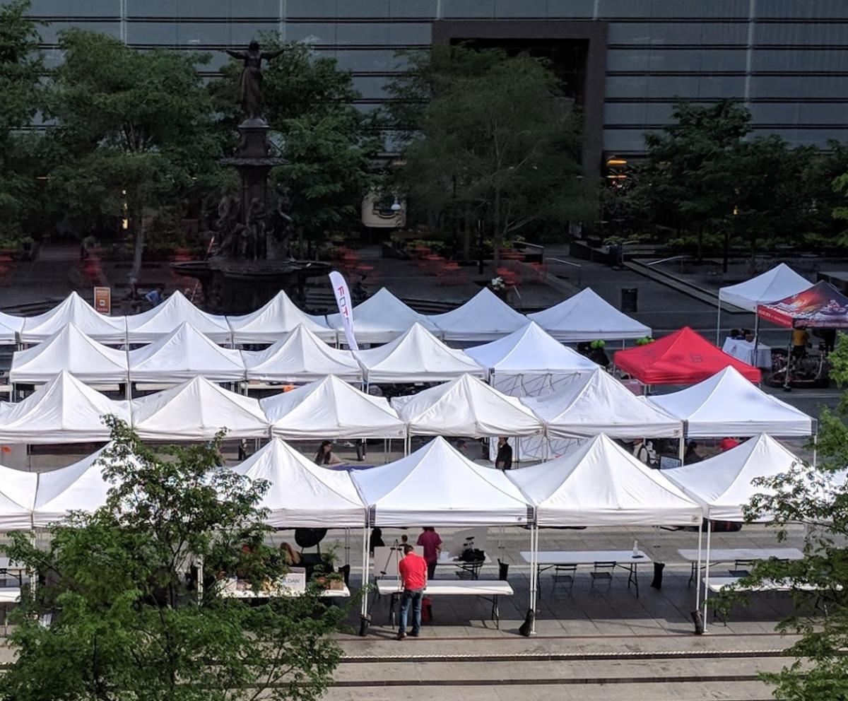 Rows of white tents on Fountain Square in Cincinnati with one red tent that reads "The B-Line" in blue lettering
