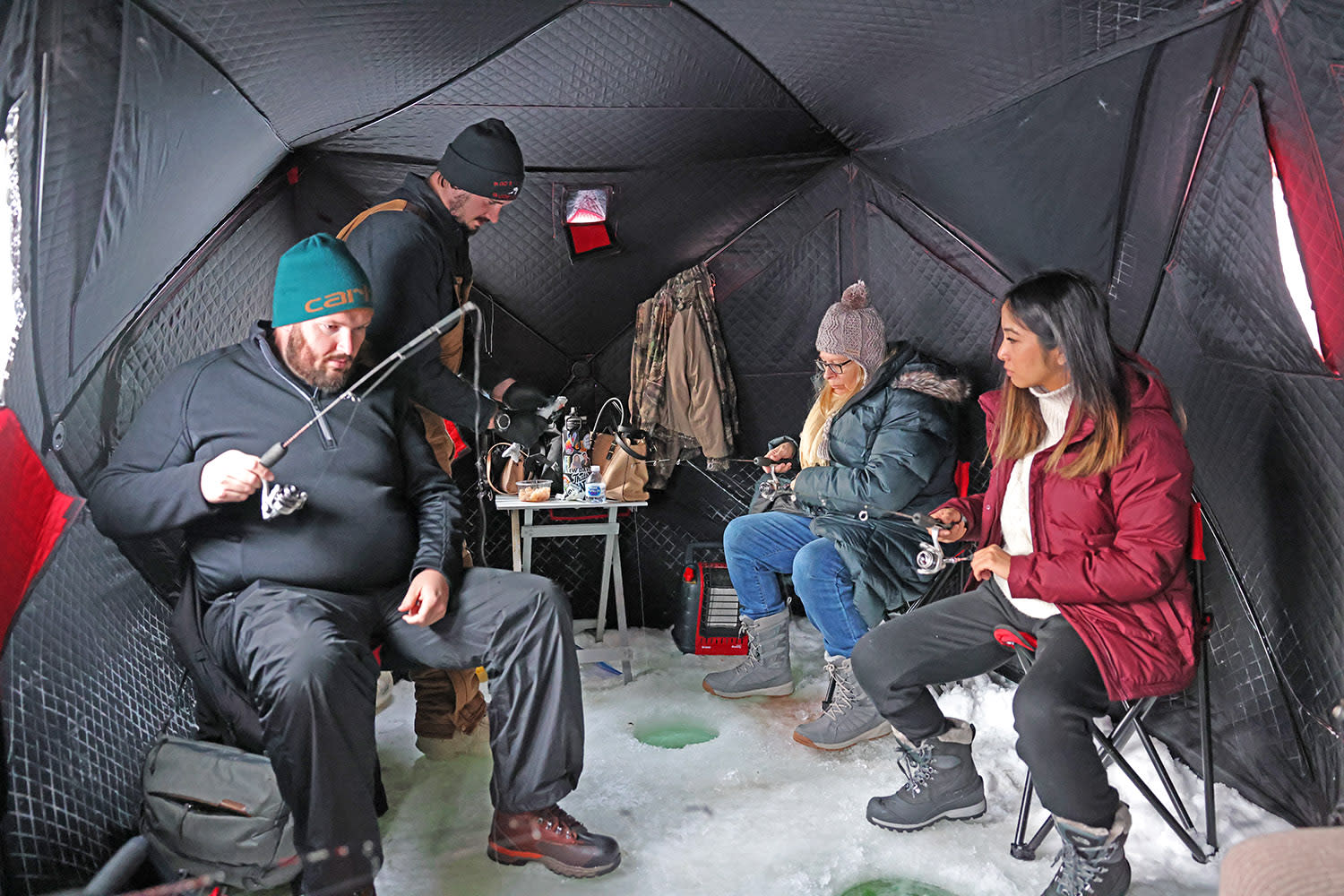 Ice fishing inside an insulated icehouse in Alaska
