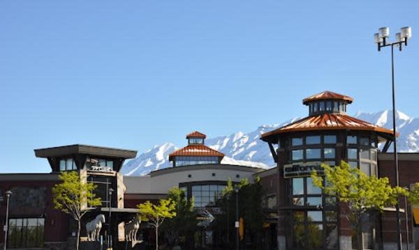 University Place South Doors. Entrance to P.F. Chang's and California Pizza Kitchen. Trees and blue skies. Mountains visible in the background.