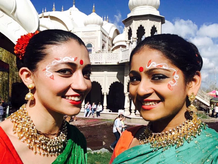 two women with Radha Krishna temple behind