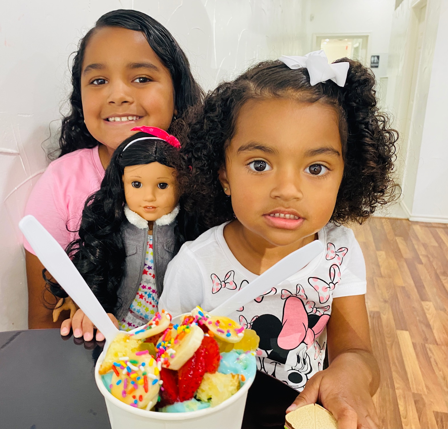 Young Kaehlani and KayKay join their doll for a yummy fruit-topped ice cream treat in Irving.