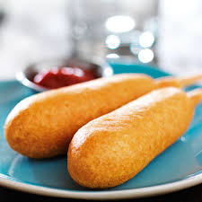 Two corn dogs on a blue plate with a side of ketchup