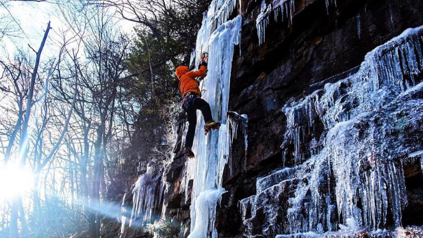 An ice climber scaling an ice-covered rock in the 'Gunks