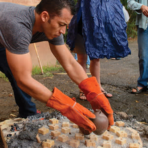 Diego Valles removes his students’ ceramics from a wood-fired kiln he made out of a steel bucket.