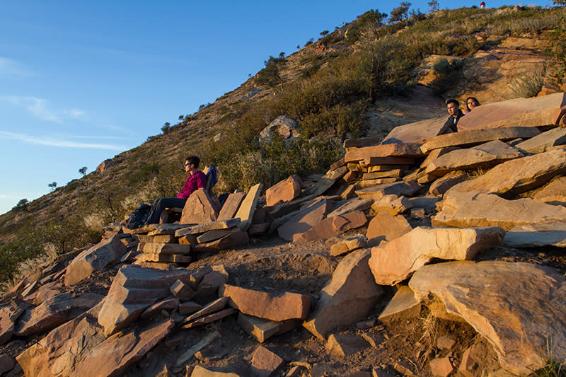 Hikers relax on stone furniture