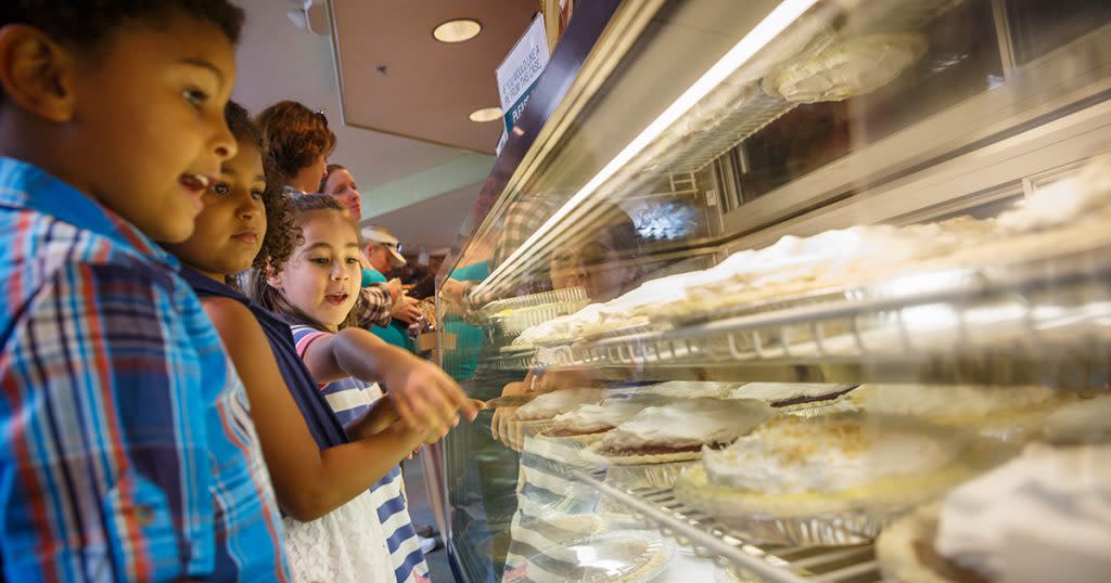 Three children look through the glass at a display case filled with pies at Das Dutchman Essenhaus Bakery in Middlebury, IN