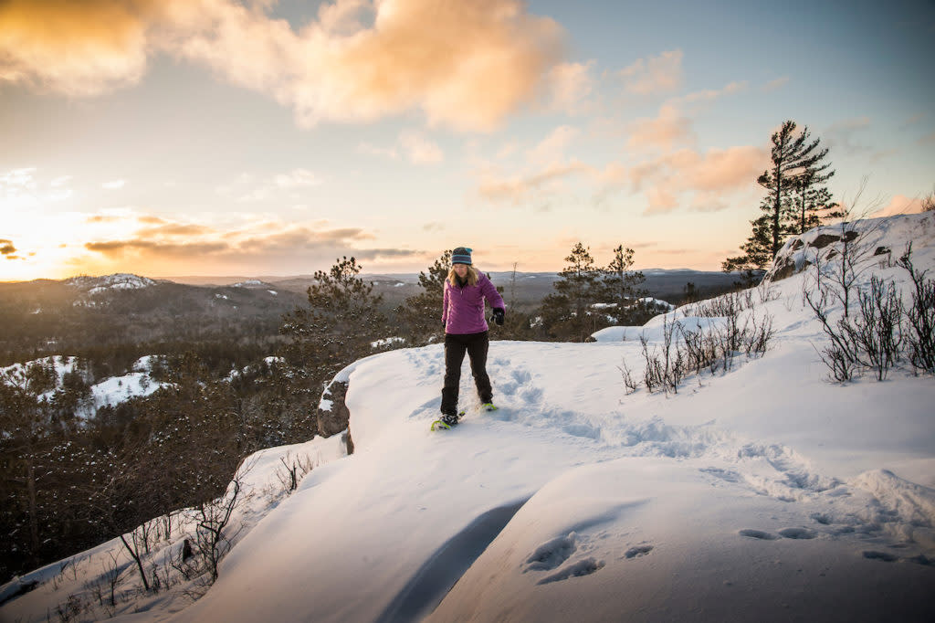 A snow shoe hiker at a scenic overlook during winter from Sugarloaf Mountain in Marquette, Michigan Upper Peninsula of Michigan.