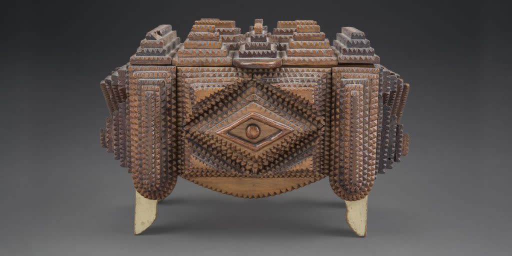 Tramp art definition, folk art of the 19th and 20th centuries utilizing recycled found materials, as cedar or mahogany cigar boxes, shaped into containers, lamps. Photo courtesy of MOIFA