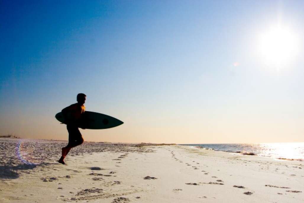 Un surfista en Cayo Perdido, en el noroeste de la Florida.