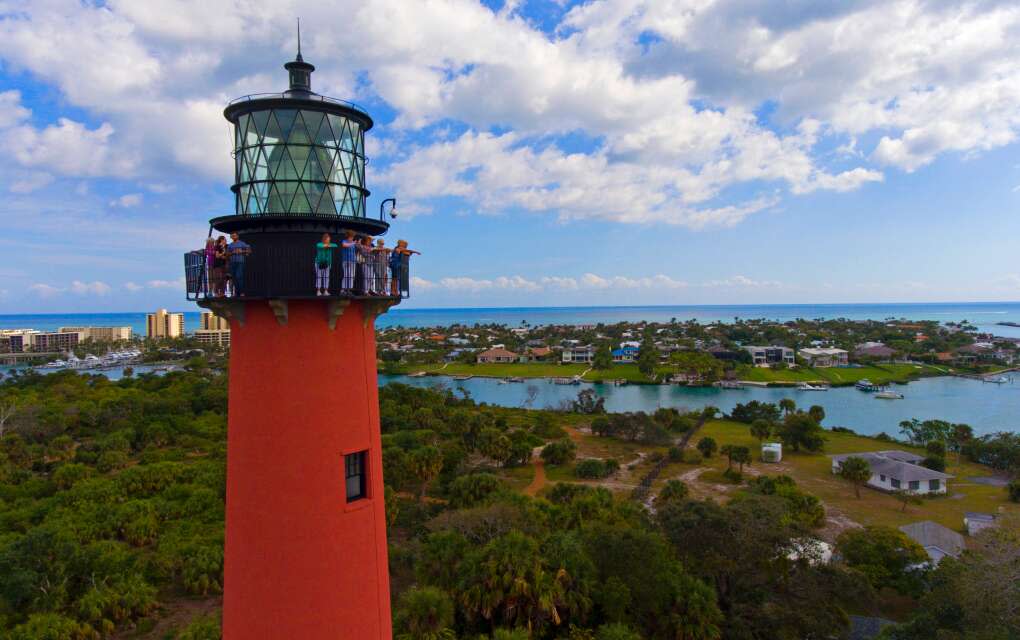 a group of tourists overlooking the town on top of the jupiter lighthouse