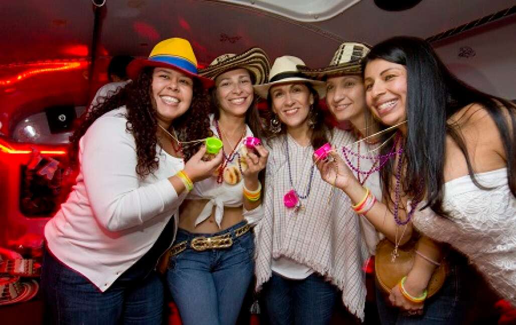 group of women posing and holding a necklace shot glasses on board of La Chiva Party Bus in Tampa