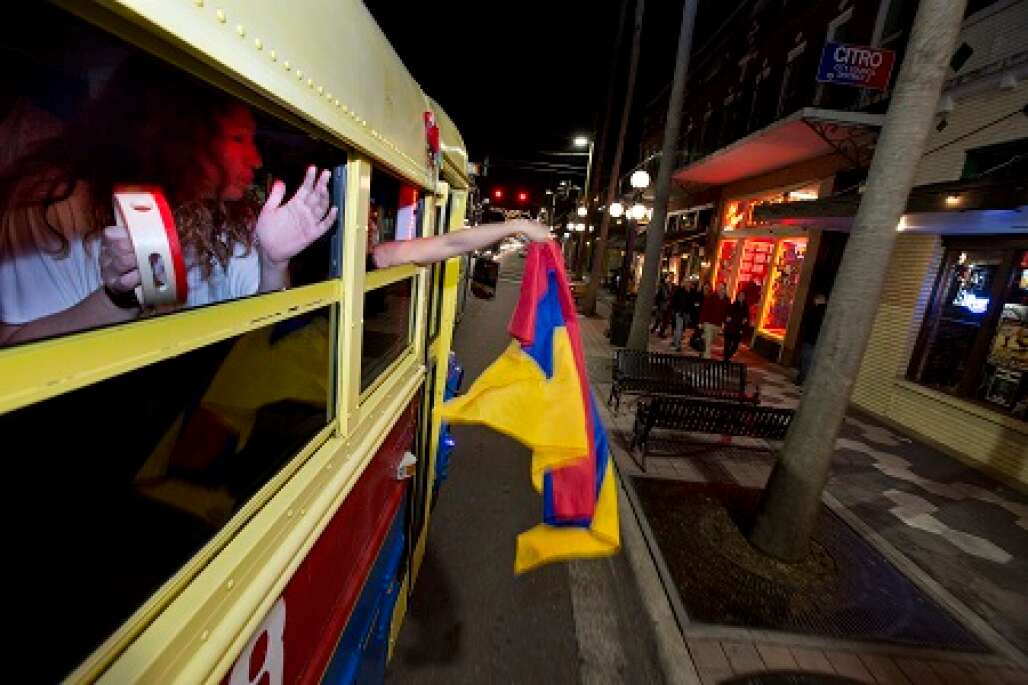 partier hangs a shirt or flag out of the window of La Chiva Tampa bus