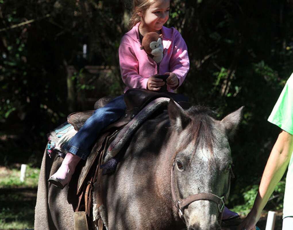 Five-year-old Lena Hession rides ''Stuffed Toy George'' at HorsePower for Kids during a benefit for a girl who is suffering from leukemia.