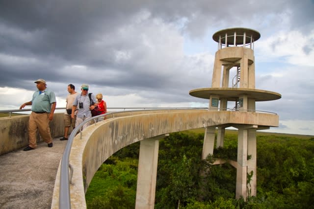 A group of tourists walking down the bridge of the Shark Valley Visitor Center