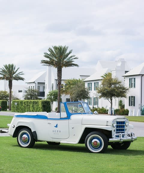 A white car parked by the beautiful green grass of the Alys Beach