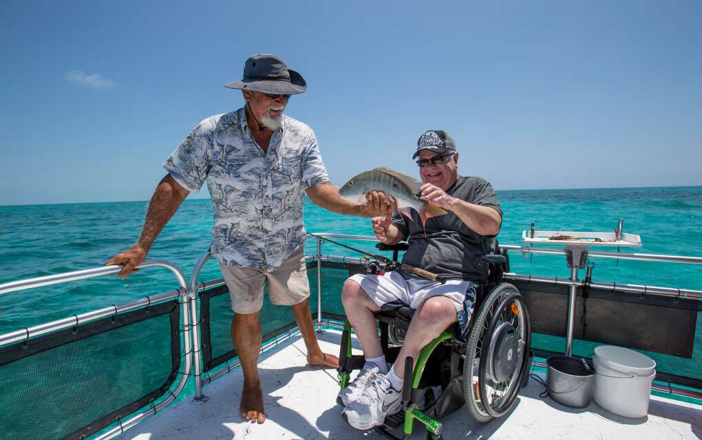Tranquil Adventures in Key Largo; a man in wheelchair admires a fish he caught