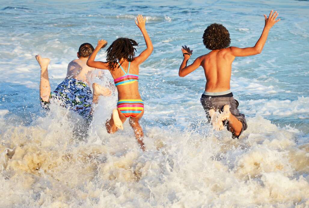 kids run splashing into the surf at Destin Beach