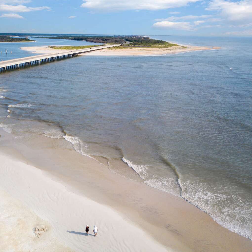 Aerial view of two men walking along the shore in Matanzas Inet