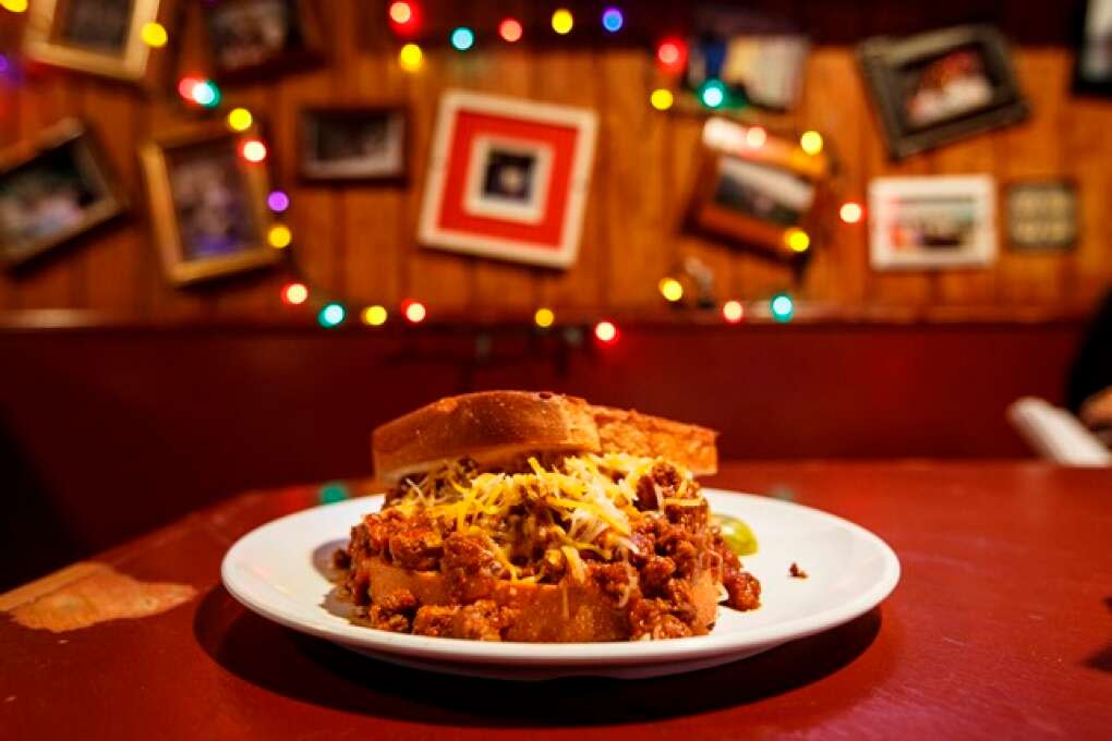 The Texas Chili Burger at Johnny’s Fillin’ Station in Orlando features a beef patty smothered in bean-less chili, topped with cheddar cheese and served on Texas toast.