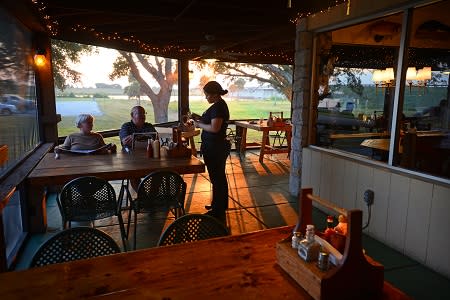 An waitress taking the order of a senior couple