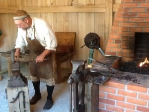 Village blacksmith works hard for visitors.