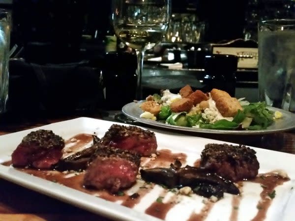 Dinner at the bar: coffee crusted beef medallions appetizer and salad bar.