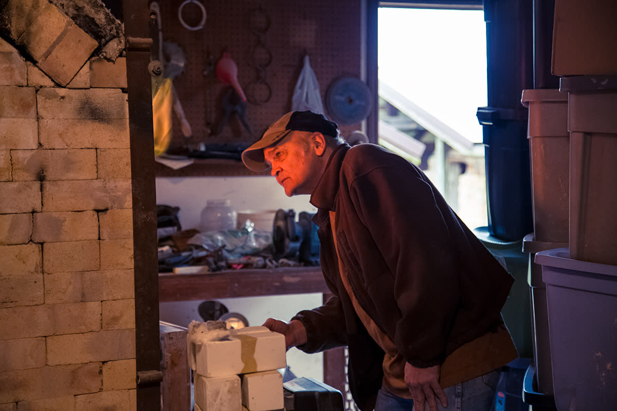Scott Shafer checking the temperature in his homemade kiln.