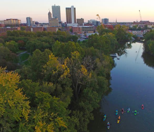 Aerial view of people kayaking on the St. Marys River in Fort Wayne, Indiana with the skyline in the background.