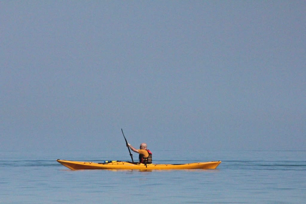 a man paddling on lake michigan