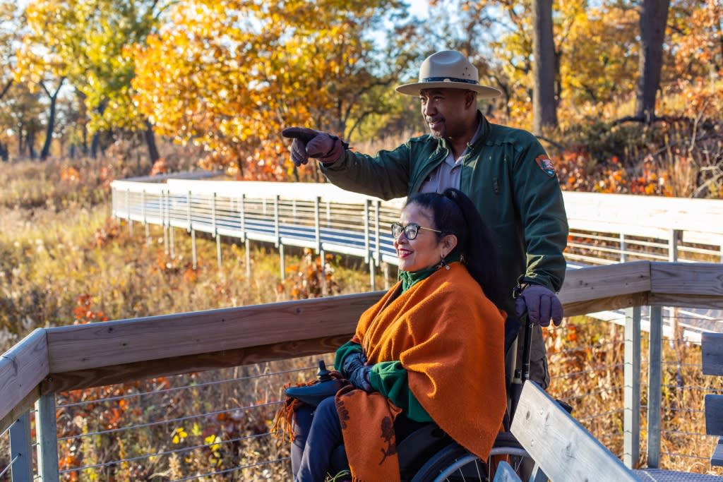 park ranger and woman view the fall colors on a boardwalk