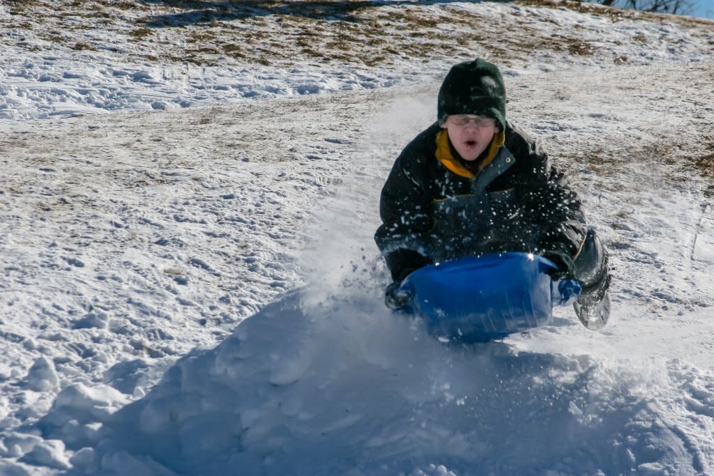 Kid sledding down hill