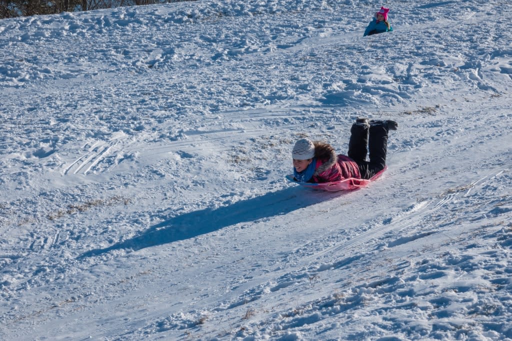 Girl sledding down a hill