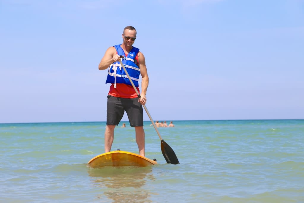 man stand up paddleboarding in Lake Michgan