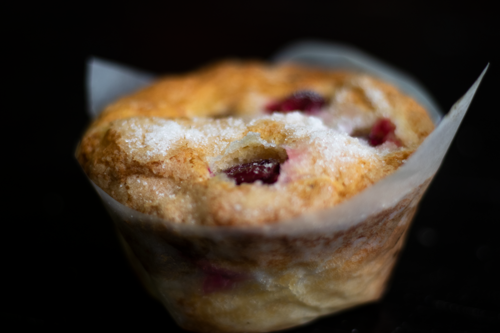 A cranberry muffin with sugar crystals on top.