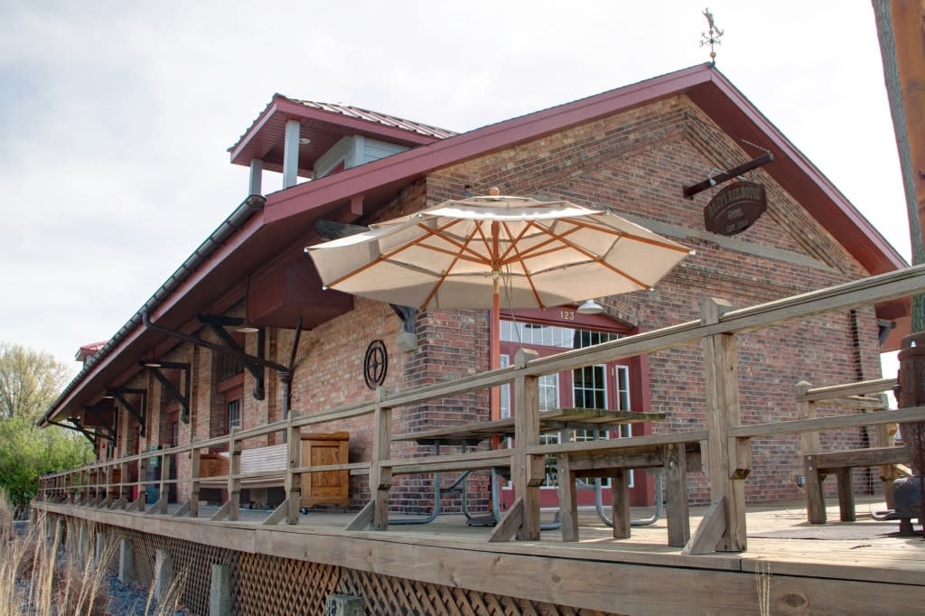 Brick exterior of a building with an umbrella and fencing 