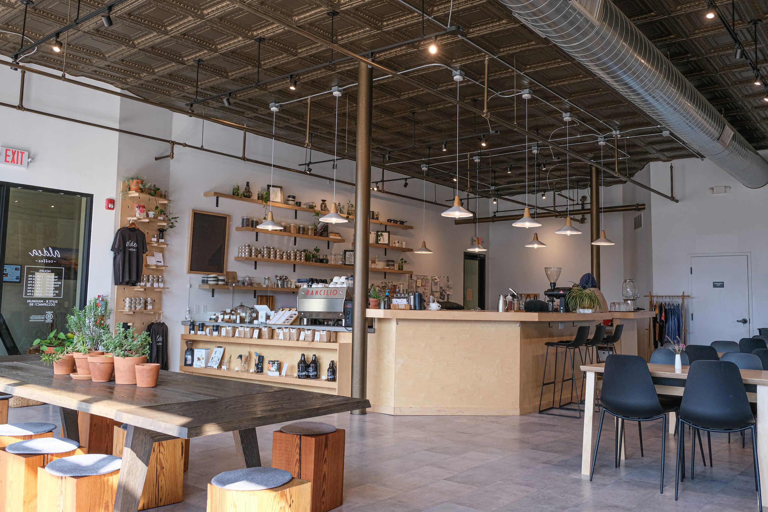 long shot of coffee shop includes light wood counter and tables