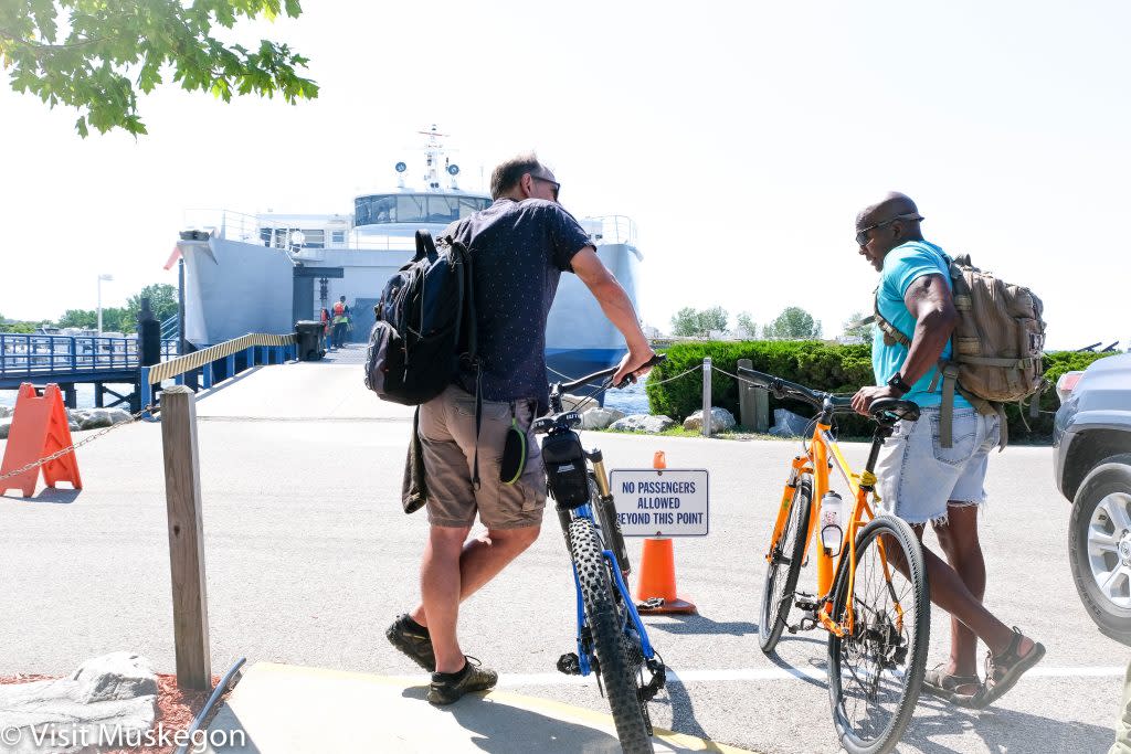 two men hold bicycles waiting to board Lake express ferry