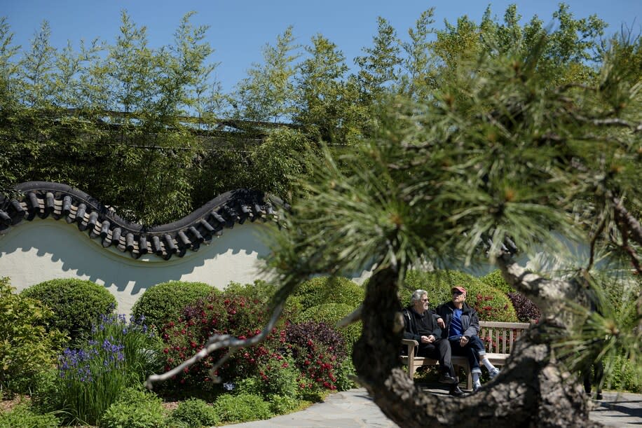 Guests chat on a bench in the bonsai section of the National Arboretum in Washington, D.C.