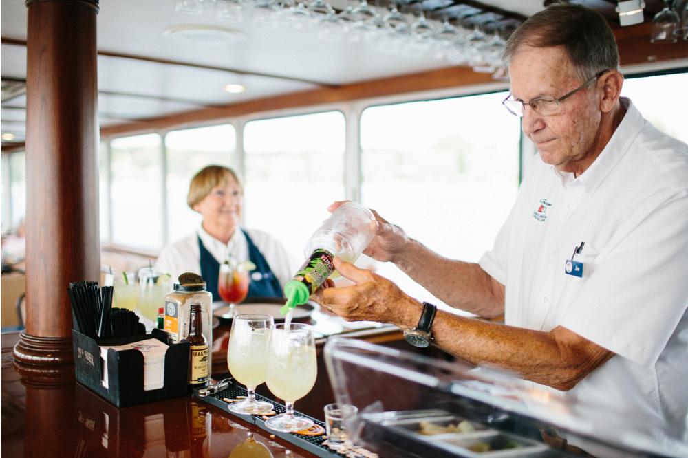 Bartender pouring drinks on board the Grand Belle